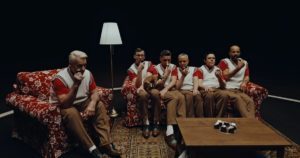 Szene aus dem Video "Angst" - Die Bandmitglieder sitzen auf einem Sofa und essen einen Schokokuss