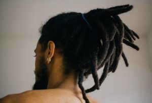 Eine Person mit Dreadlocks von hinten