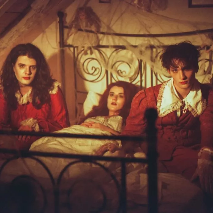 Die drei Bandmitglieder posieren im Bett