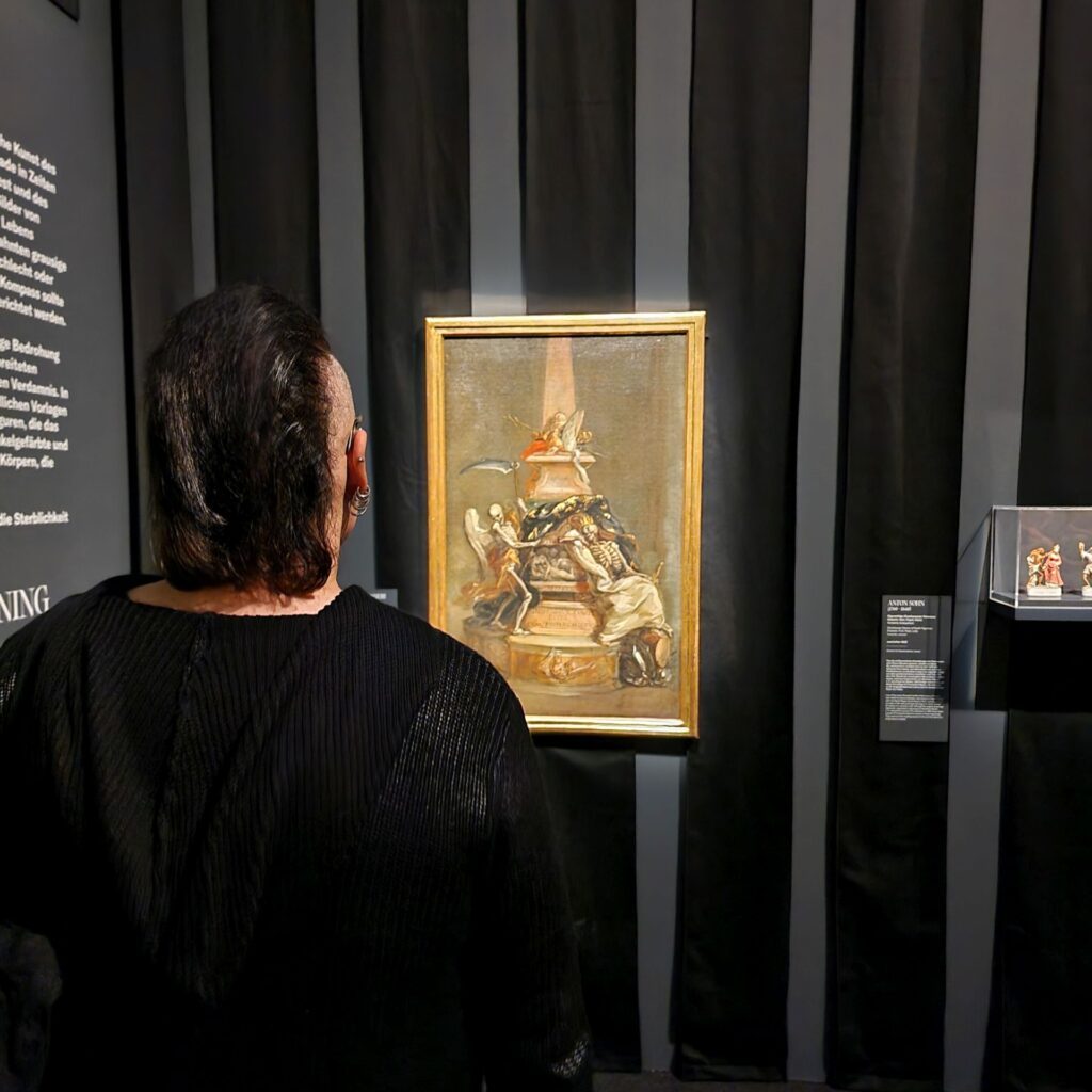 Robert Forst betrachtet Bilder der Ausstellung