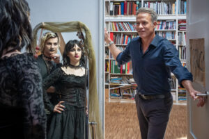 "SOKO Leipzig - Schwarz ist alle Farben": Jojo Keller (Karl Seibt) und Lotte Trautzschke (Carlotta Bähre) sind über einen Spiegel in Gothic-Klamotten zu sehen. Beide lächeln Jan Maybach (Marco Girnth) herausfordernd an, welcher in der Zimmertür steht und leicht überfordert lächelt.