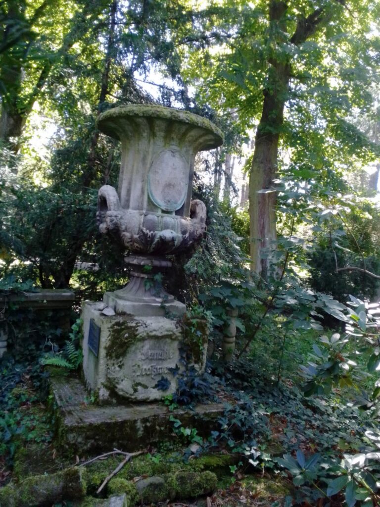 Antike Urne auf Sockel auf einem historischen Friedhof