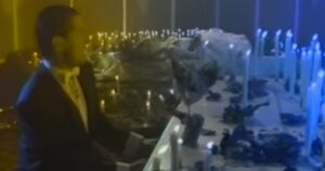 Falco sittzt an einem mit Kerzen geschmückten Klavier und singt Jeanny