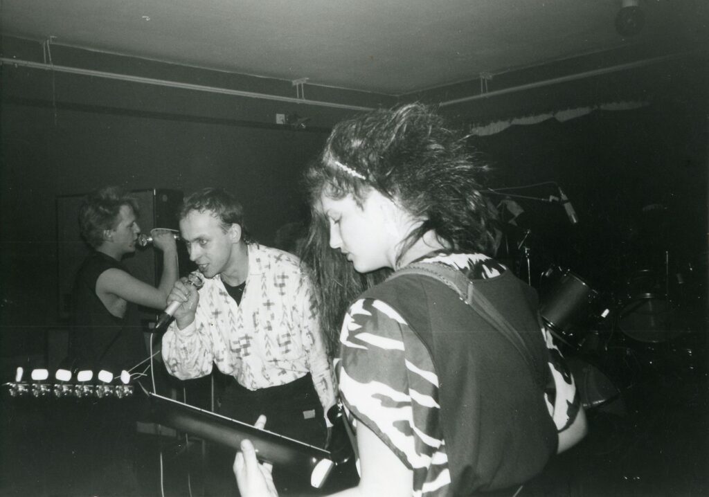 Rosengarten live 1986, schwarz-weiß – Sänger am Mikrofon und Gitarristin mit langen Haaren auf einer kleinen Jugendklub-Bühne